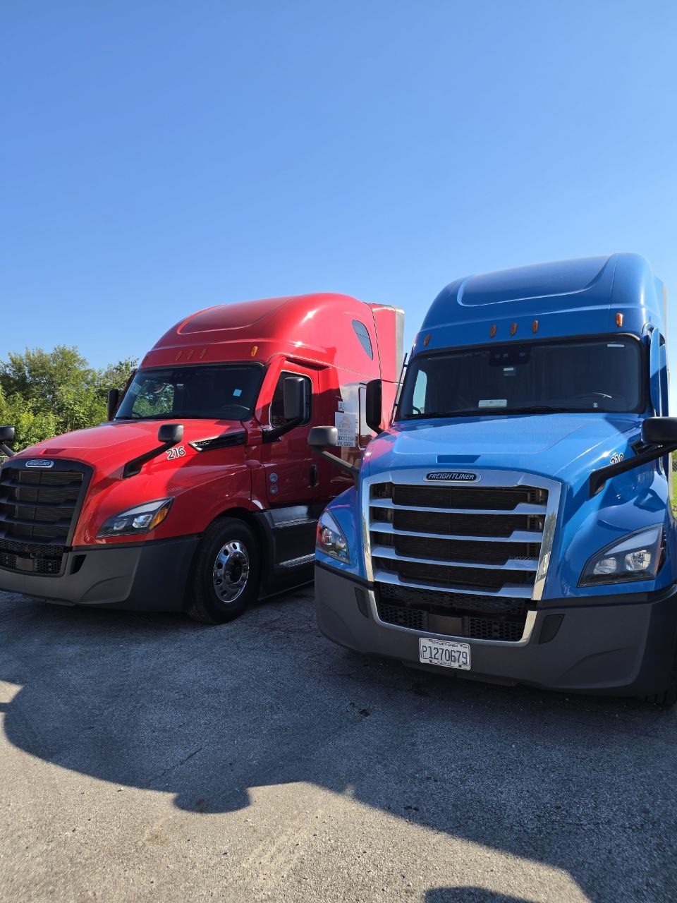 Red and blue Freightage trucks side by side
